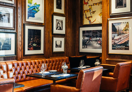 Corner table in the Oak Room, featuring photos and artwork from the Cambridge Club's Canadian Collection