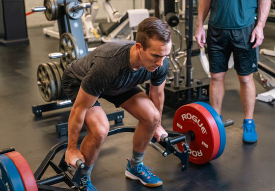 Young man lifting weights in the Cambridge Club gym