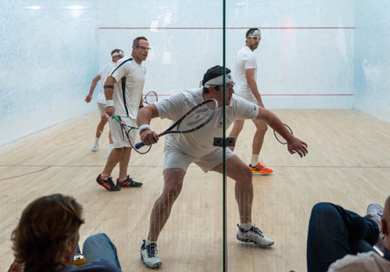 Four men playing squash one the doubles squash court at the Cambridge Club in downtown Toronto