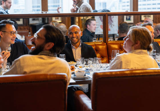 Table of young men and a woman at the Cambridge Club's Whiskey Tasting event in the Oak Room