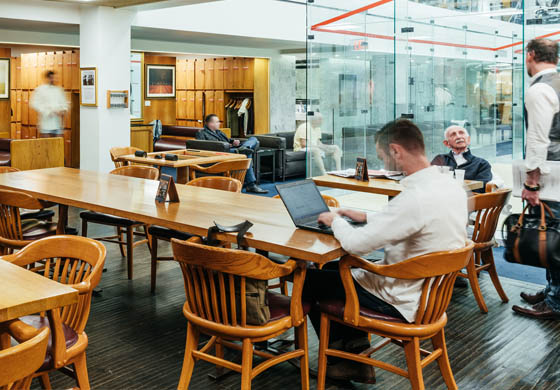 Men working and networking in the Sports Lounge at the Cambridge Club, located next to our squash courts