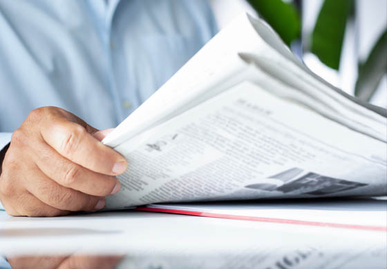 Close-up of man's hands reading a newspaper