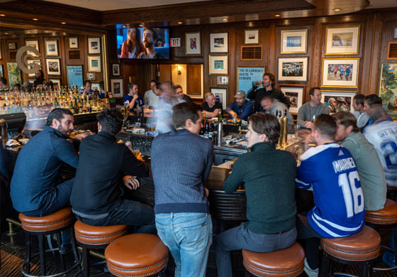 Men crowded around the bar in the Oak Room at the Cambridge Club