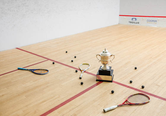 Jim Bentley Cup on the squash court at the Cambridge Club surrounded by squash balls and racquets