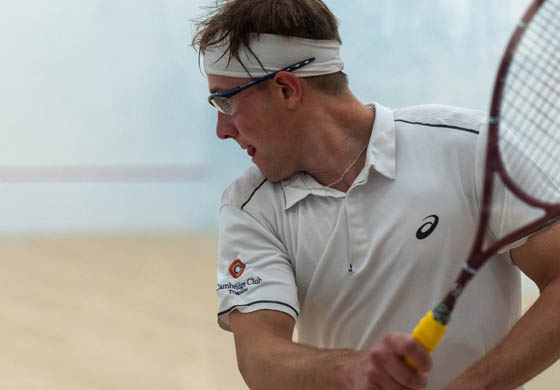 Sweaty young man playing squash on the Cambridge Club singles squash court