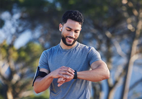 Young fit man, preparing to run outside, checking his watch